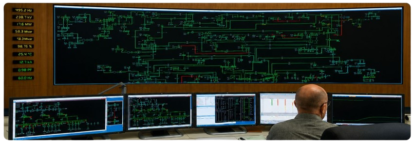 Person monitoring electrical grid on multiple monitors